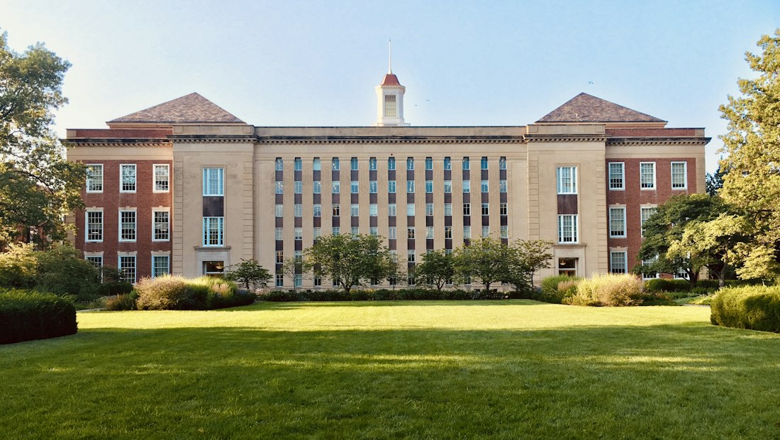 Traditional brick school building across a green lawn